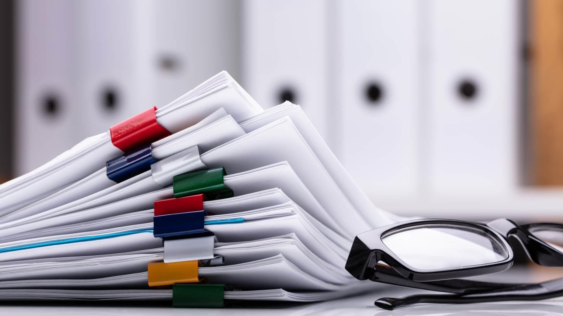 A pile of document with a pair of glasses